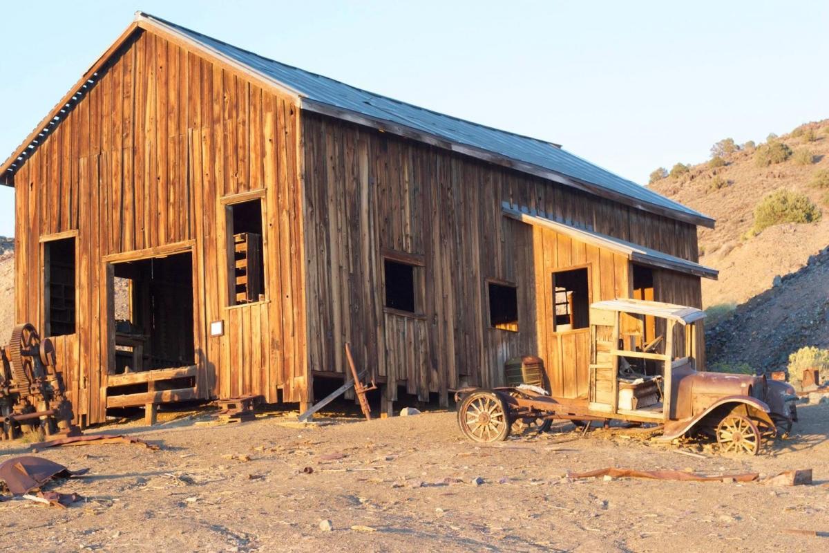 Abandoned wooden structure surrounded by old equipment